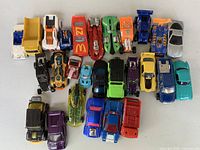 Top-down view showing 25 die-cast cars and trucks in varied colours and styles