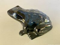 Side view of glossy drip-glaze ceramic frog