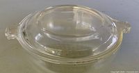 Side view of assembled clear glass casserole with lid showing tab handles