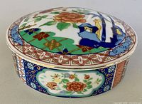 Side view of oval porcelain trinket box with lid showing body decoration