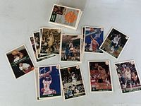Assortment of Front Row basketball cards spread out plus stack in plastic case showing players