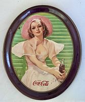 Front of oval Coca-Cola tray showing illustration and rim