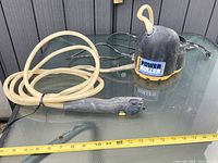 Base unit, clear hose and handle laid out on glass table