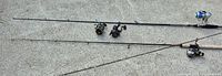 Two assembled fishing rods with reels plus detached reels and additional rod sections
