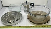 Group shot showing all items: nested cake pans, glass baking dish, moka pot, glass bowl, pie plate