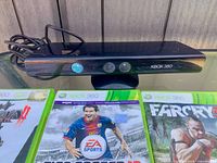 Front view of Kinect sensor with three game cases partially visible