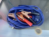 Cables coiled in blue zippered bag, clamps visible