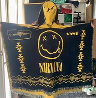 Full view of poncho worn, black side outward with yellow graphics