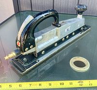 Full view of sander left side showing handle, shoe, and brass air inlet