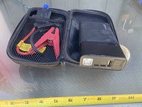 Open case showing jump starter, clamps and interior mesh pocket