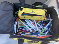 Open Ryobi bag showing large quantity of assorted markers, pens, pencils and yellow bee pencil pouch