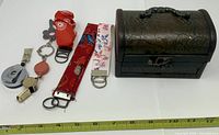 Overall lot showing trinket chest, fabric straps, badge reels, whistle and measuring tape for scale