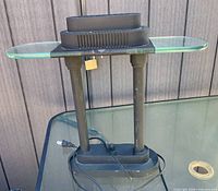 Front view of black metal desk lamp with glass shelf shade and power cord