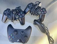 Three PlayStation wired controllers, one Wii Nunchuk, one Xbox wireless controller without back cover
