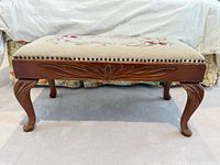 Full side view showing carved apron, cabriole legs and overall bench form