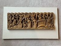 Full view of carved wood relief mounted on linen board