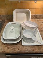 Group of CorningWare dishes and lids on countertop