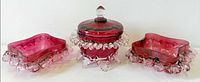Front view of entire three-piece cranberry art glass set