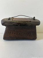 Front view of carved wooden box with handle and lid