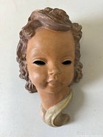 Front view of terracotta lady head wall mask