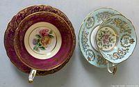 Teacups nested in saucers showing interiors and gilt decoration