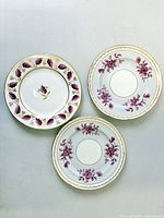 Three 8-inch Foley plates, overhead view showing patterns and gilt rims.