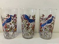 Front view of all three decorated juice glasses standing side by side
