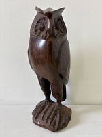 Front view of carved rosewood owl on base