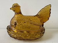 Side view of amber glass hen on nest showing overall form