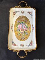 Top view showing floral porcelain tray with brass handles and feet
