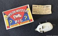 Toy pig, illustrated box lid, instruction slip
