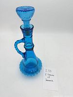 Full view of assembled blue glass bottle with stopper