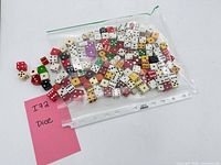 Bag containing assorted coloured dice beside note labelled 172 Dice