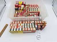 Overview of plastic bin filled with boxed vacuum tubes and separate rows of tubes