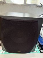 Front view showing black cloth grille and cabinet