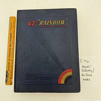 Blue hardcover 42nd Rainbow Infantry Division WWII history book front cover with ruler for scale