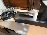 Soundbar top with Samsung remote, wireless receiver module, bundled cables