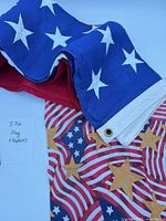 Folded blue canton with white stars, red stripes section, portion of patterned napkin