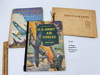 Overall view of scrapbook and two aviation books with ruler for scale