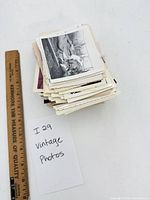 Stack of vintage photos with ruler showing scale and handwritten count