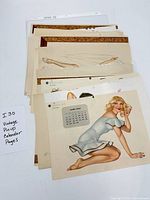Stack of loose vintage pin-up calendar pages