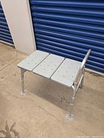 Full side view of bathtub transfer bench showing frame, seat panels, legs, and handrail