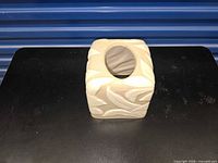 front angled view of cream ceramic tissue box cover showing raised leaf pattern