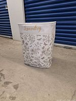 Front view showing gold "Laundry" text and floral butterfly print