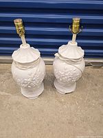 Front view of both white porcelain baluster jar lamps with cords wrapped around necks