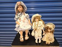 Three porcelain dolls displayed together