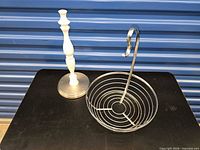 Chrome fruit bowl with banana hanger beside white paper towel stand, frontal view