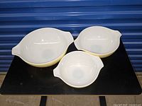Top view of three nesting Pyrex Shenandoah bowls showing size gradient and handles