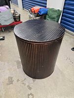 Closed cylindrical wood slat hamper showing exterior finish