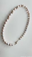 Full view of pearl necklace laid flat to show length and bead arrangement